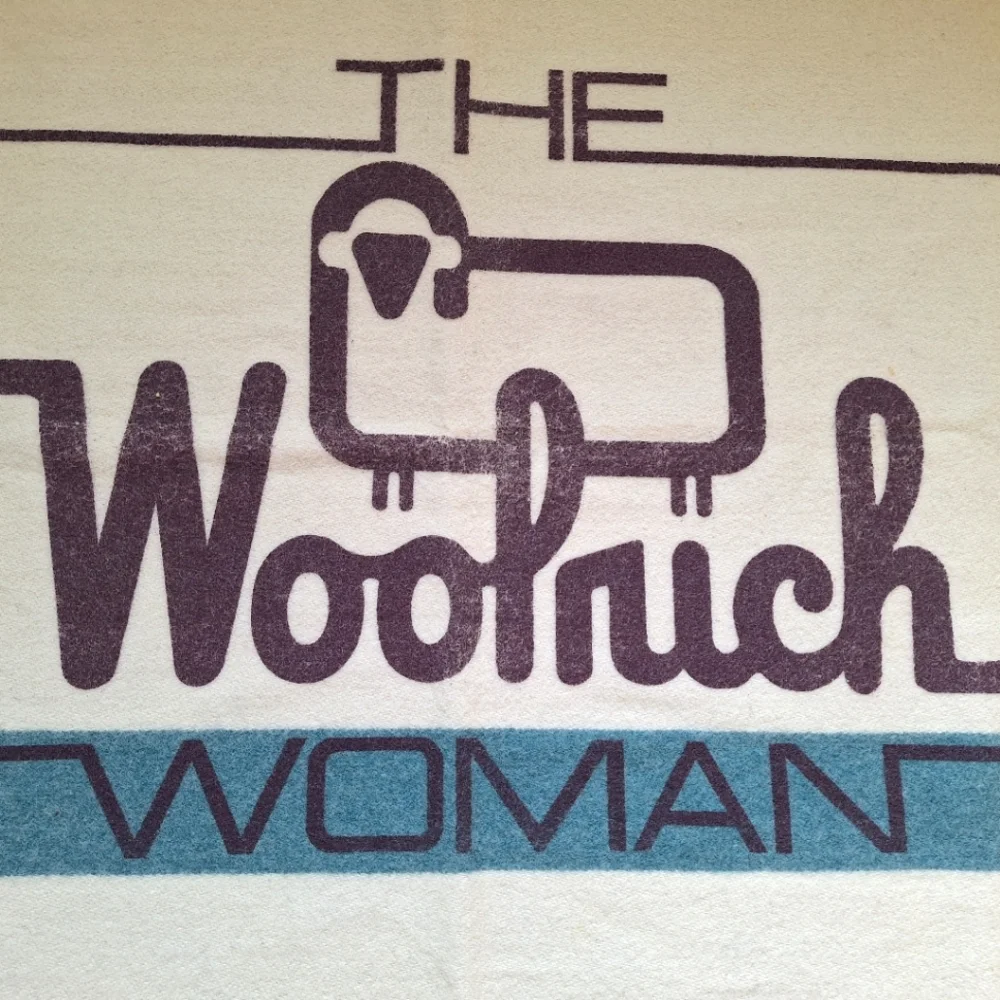 The Woolrich Woman cream, brown and blue Woolrich sheep logo heavy wool blanket